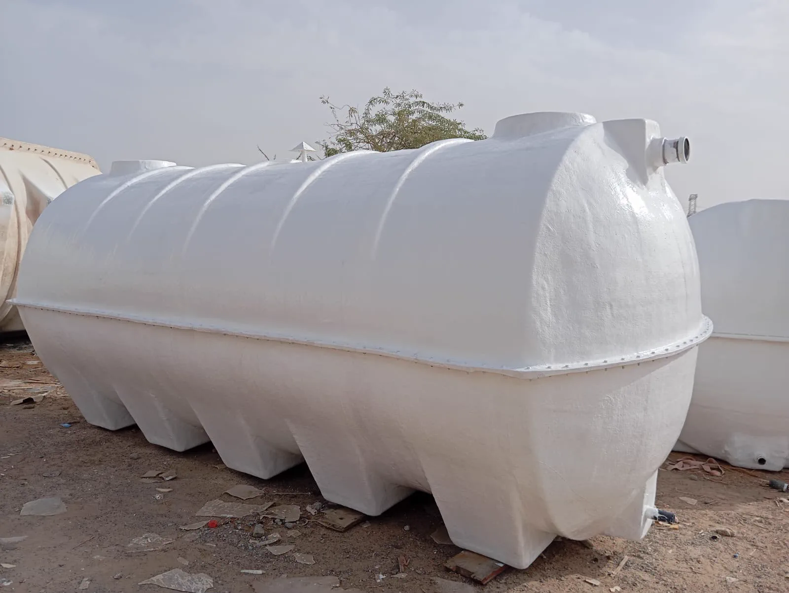 Horizontal cylindrical GRP water tank in the yard