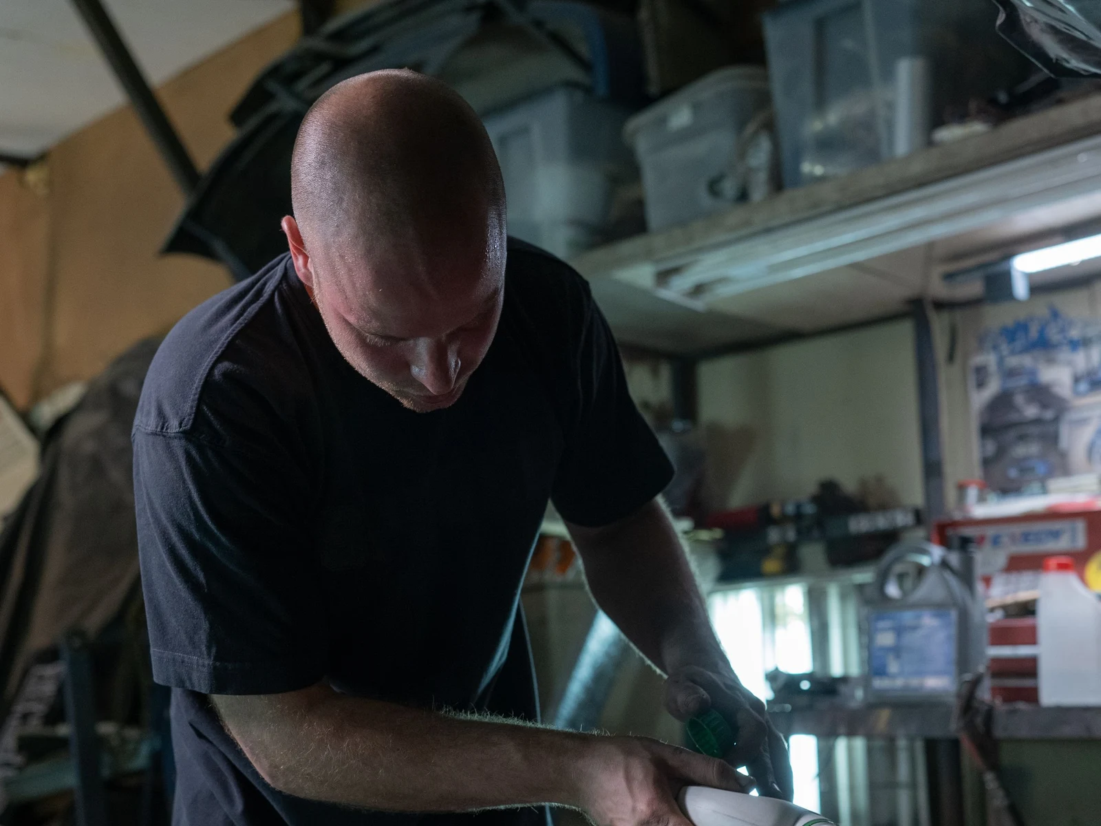 Coolant being poured from a plain container in a workshop