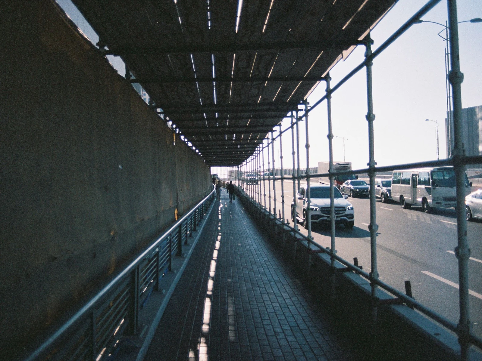 A covered pedestrian walkway alongside a live road
