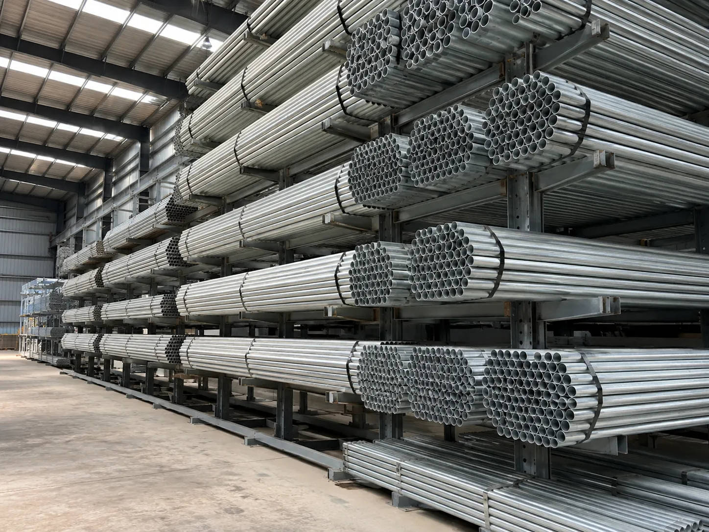 Galvanised pipe bundles racked under cover, bright zinc finish